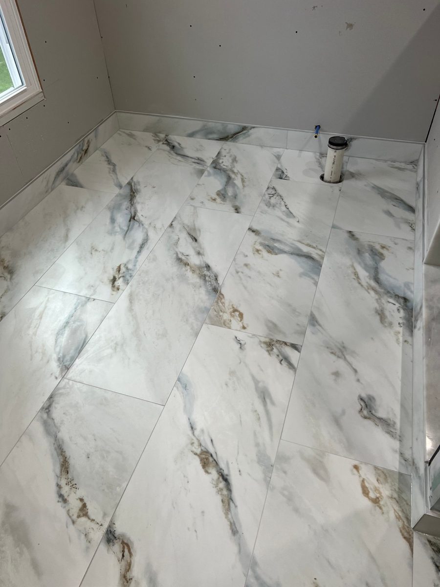 Large format marble-effect floor tiles installed across a room
