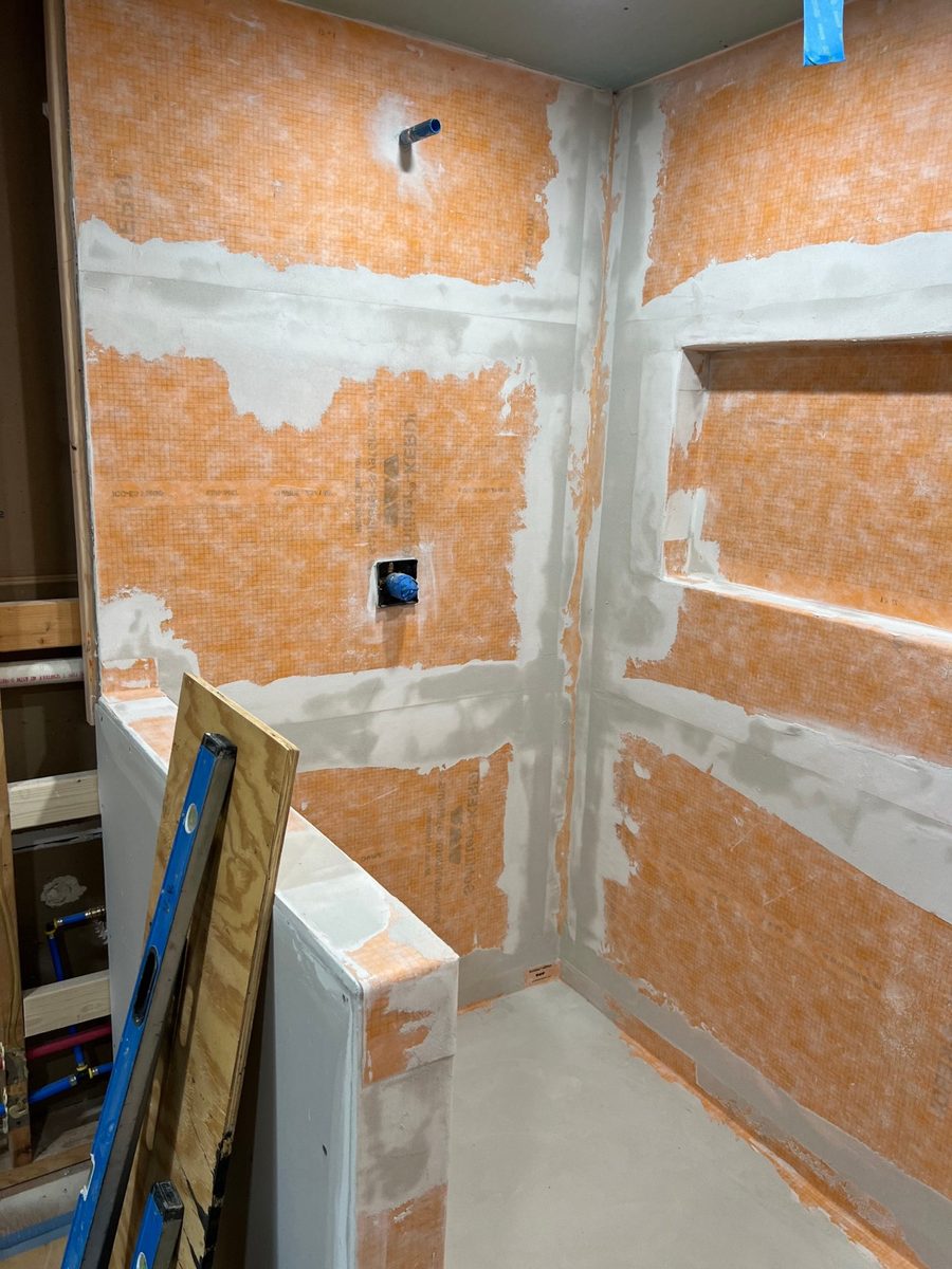 Kerdi waterproofing membrane on a shower wall before tile, the layer acrylic panels skip