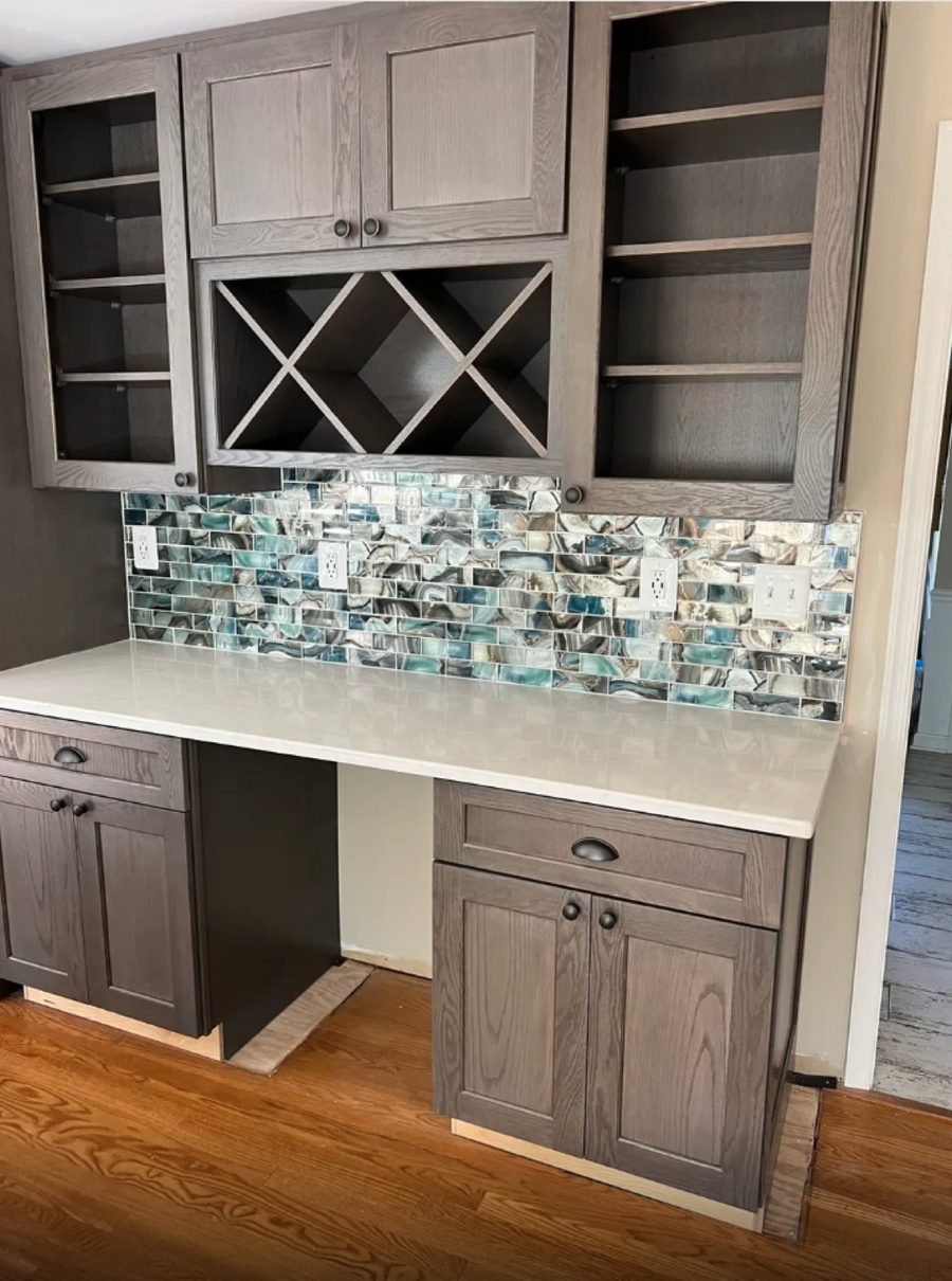 Iridescent blue and cream glass mosaic tile backsplash on a wet bar