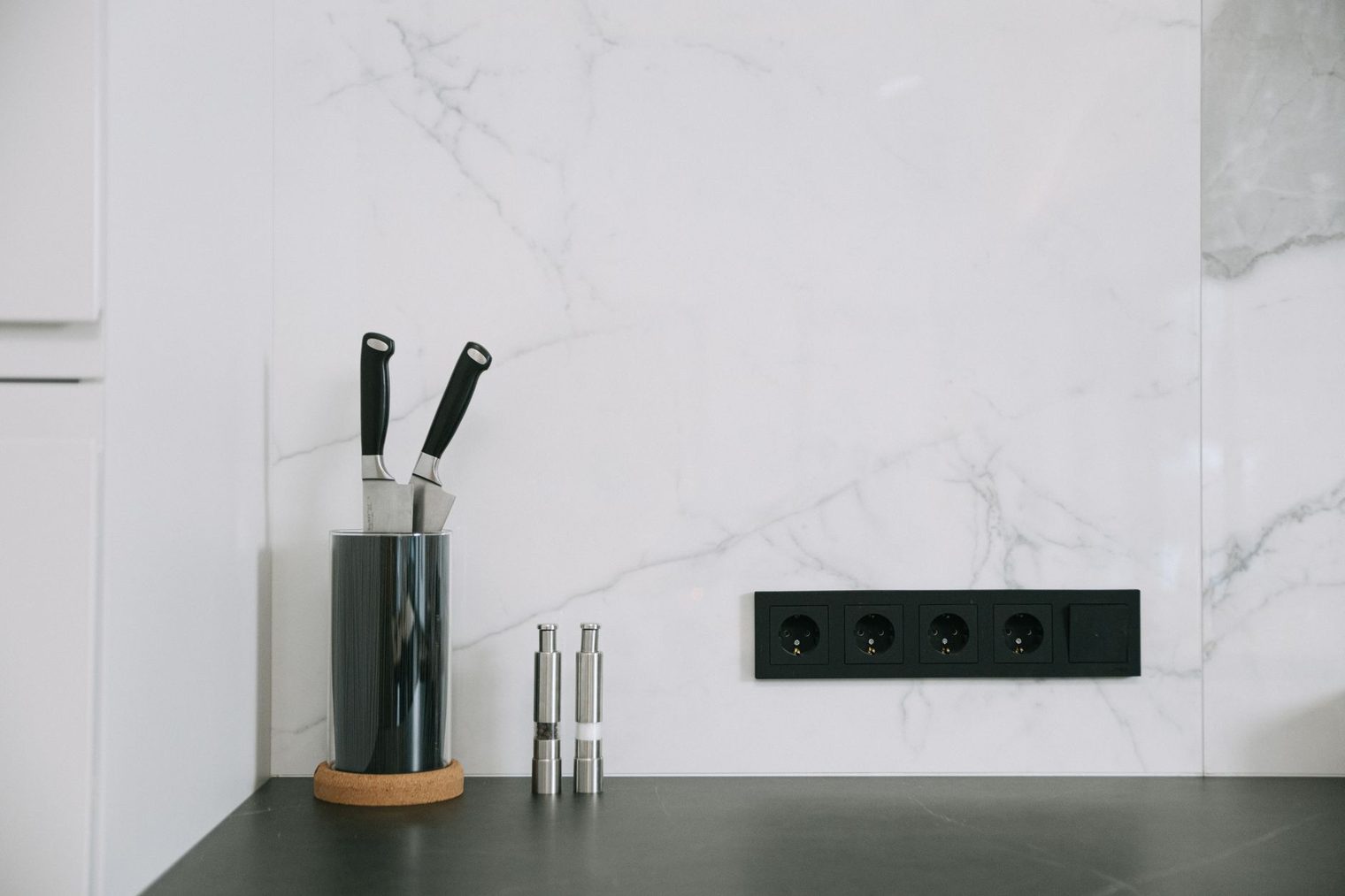 White marble backsplash running up a modern kitchen wall behind the counter