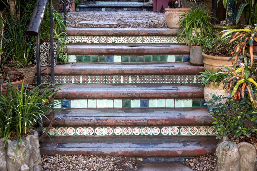 Outdoor garden steps with patterned ceramic tiled risers between stone treads
