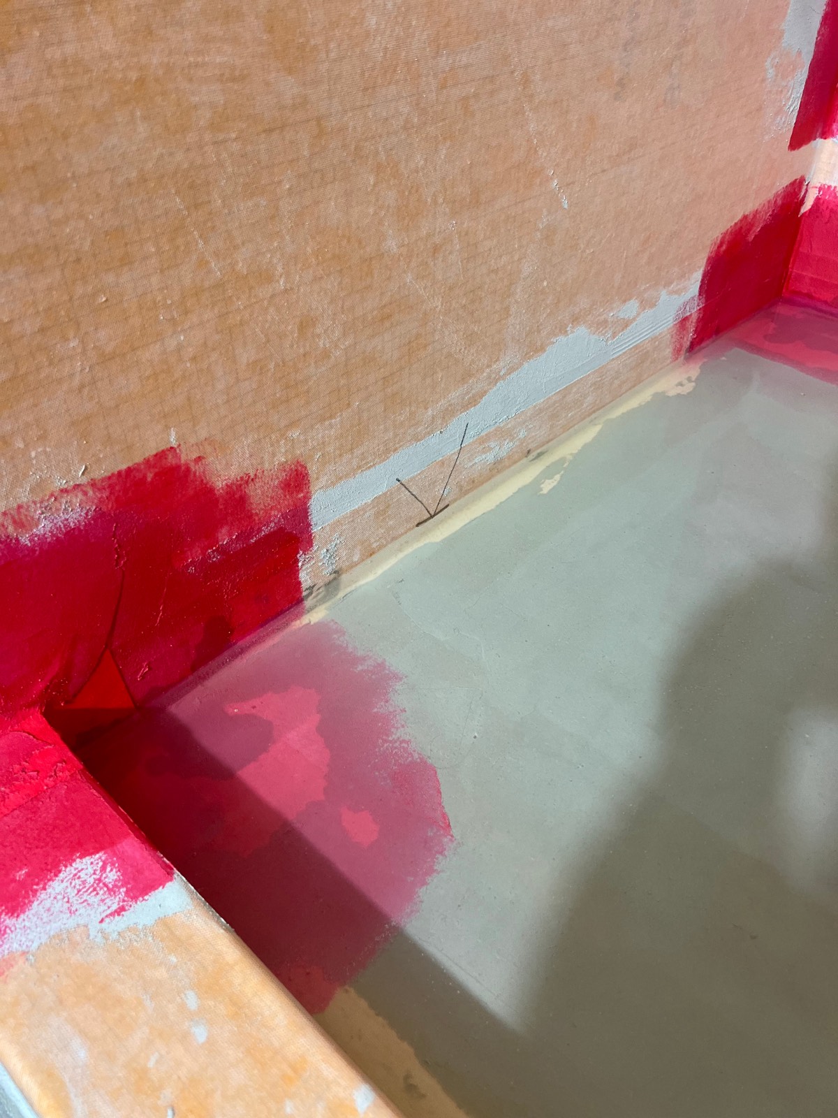 Shower pan prepared and waterproofed with a consistent slope toward the drain, ready for tile