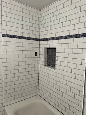 White subway tile bathtub surround with accent band
