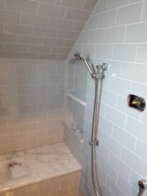 White subway tile shower with marble bench